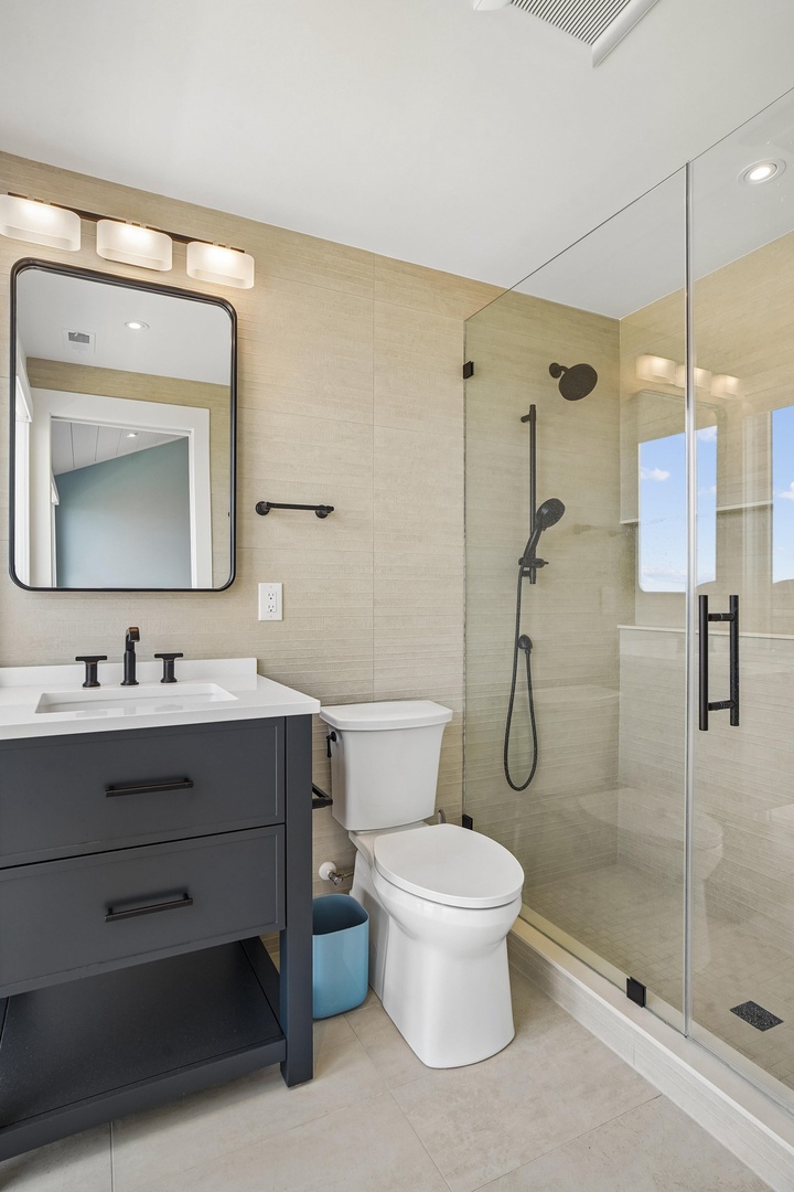 Refresh in your modern bathroom, where warm tones meet sleek black fixtures. The spacious walk-in shower and stylish vanity create a spa-like retreat for your daily routine.