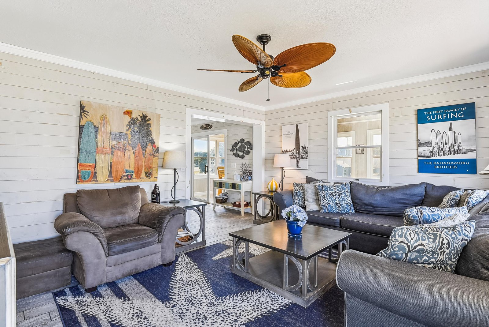 Gather in this bright living room with tropical ceiling fan and coastal vibes. Sink into the plush seating, share stories, and let the surf-inspired art transport you to beach days ahead.