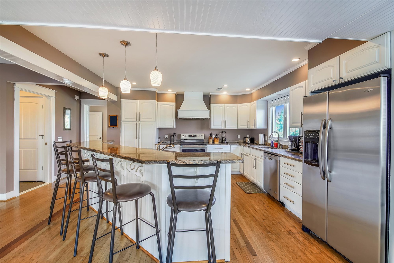 This spacious kitchen features granite counters, stainless appliances, and a welcoming island—perfect for preparing meals or enjoying your morning coffee while planning your day's adventures.