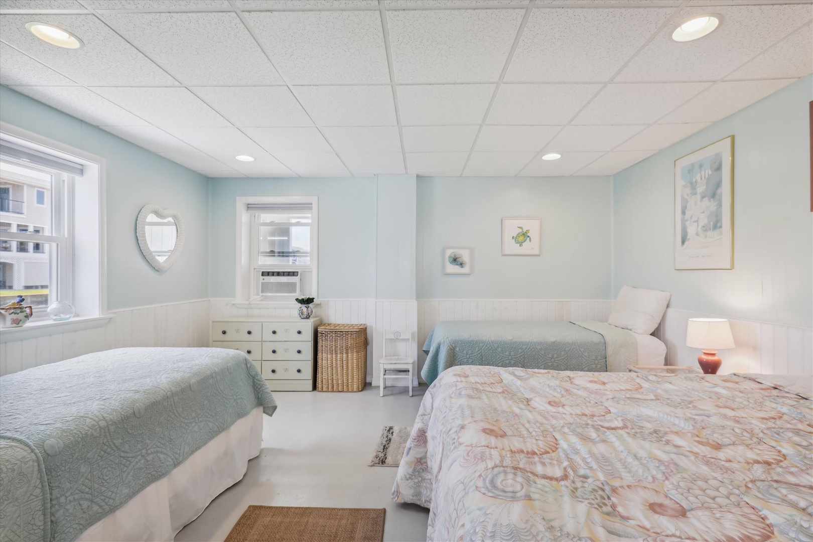 Settle into your coastal-inspired bedroom featuring soft, beachy hues and multiple comfortable beds—perfect for families or friends sharing restful mornings by the sea.