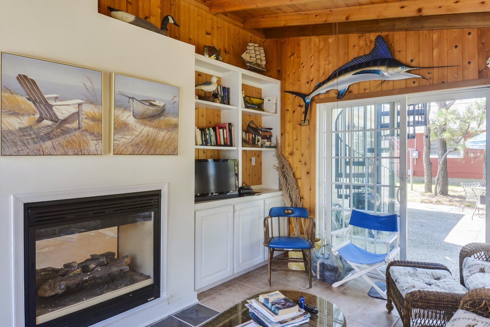 Gather by the fireplace in your cozy living room, where nautical charm meets mountain comfort beneath soaring wood ceilings and natural light.