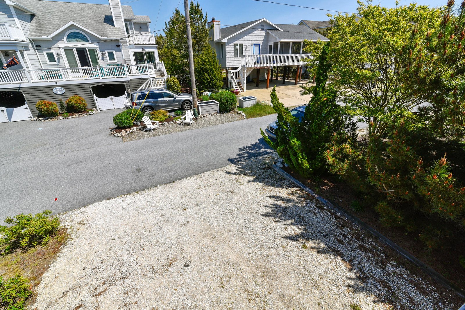 Quiet coastal neighborhood with comfortable beach homes, lush greenery, and convenient parking—a charming setting for your seaside getaway.