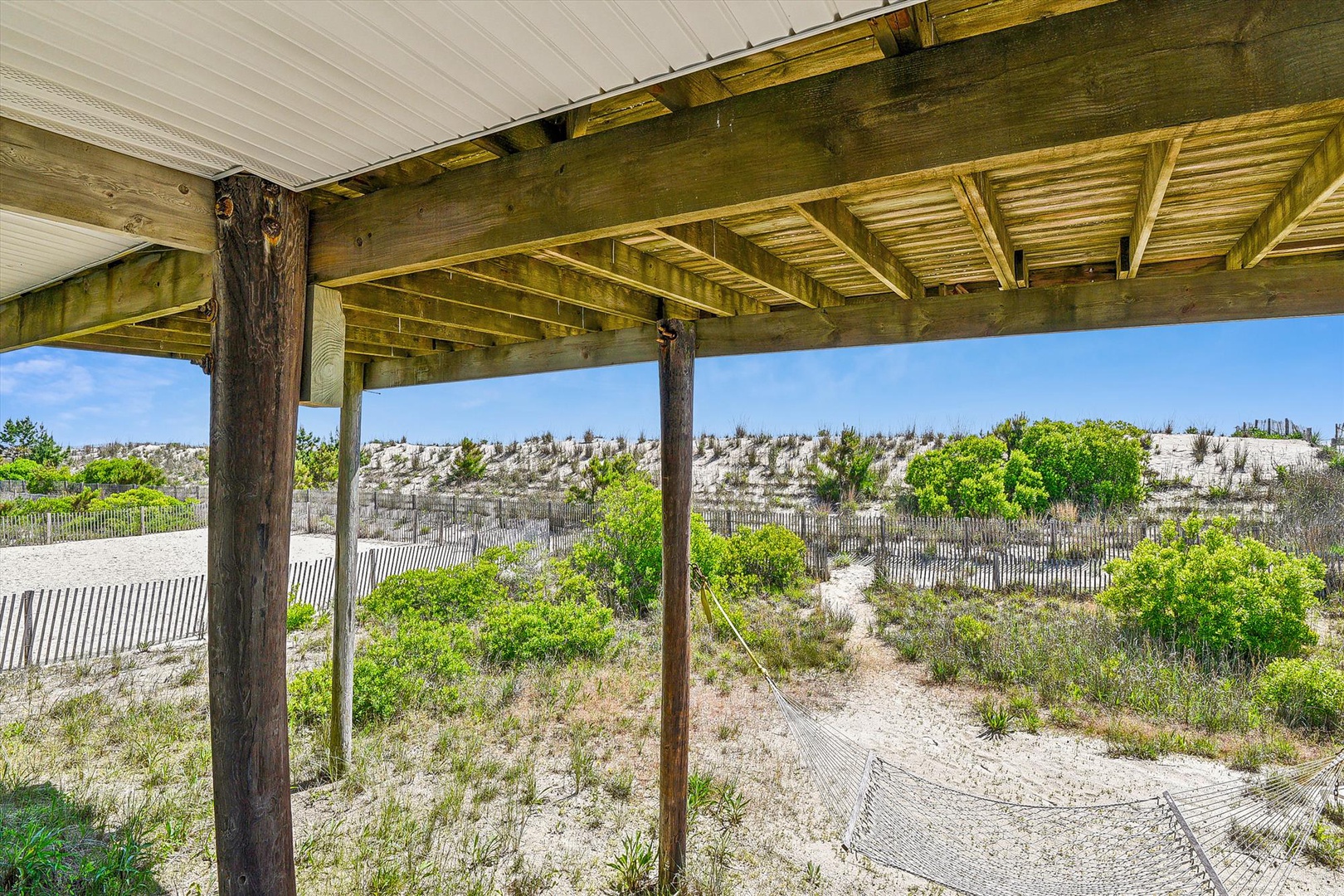 Coastal dunes and natural vegetation frame the property's beachside location, offering a tranquil connection to the surrounding landscape.