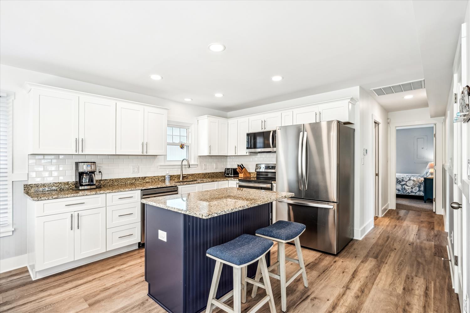 Your fully-equipped kitchen sparkles with white cabinetry, granite countertops, and stainless steel appliances. The center island invites morning coffee moments and meal prep together.