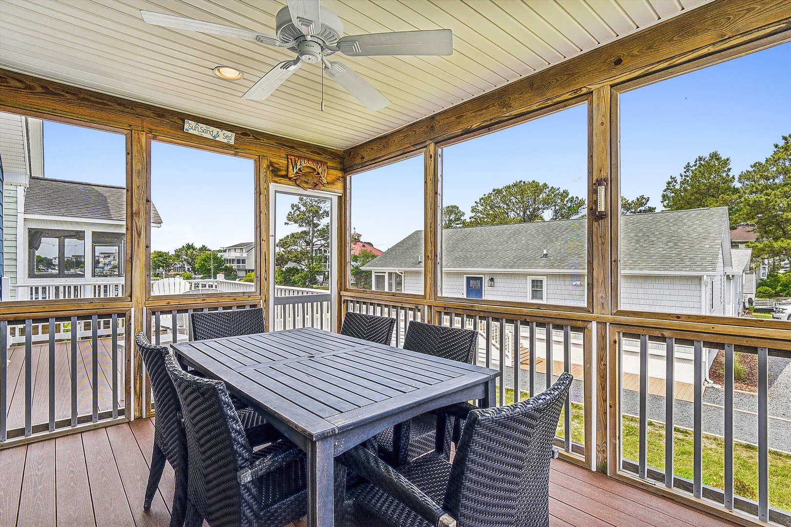 Your screened porch features a dining table for six, ceiling fan, and peaceful neighborhood views—perfect for morning coffee or casual meals in the fresh air.