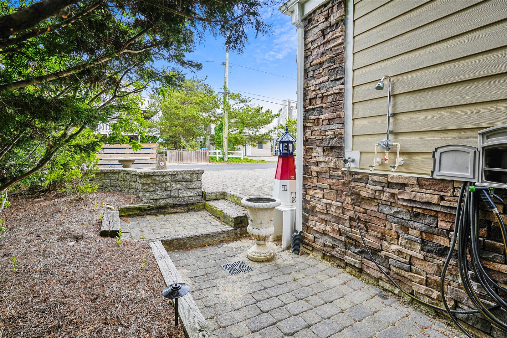 The property features a private outdoor shower area with decorative stone accents, perfect for rinsing off after beach days or outdoor adventures in this coastal neighborhood.