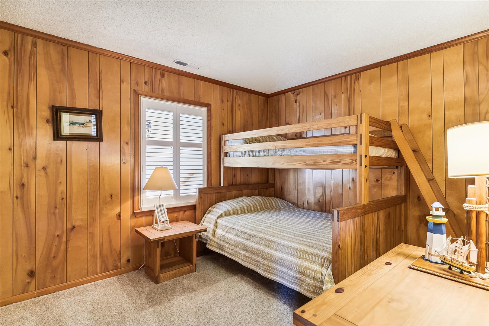 Cozy bunk room wrapped in warm knotty pine—perfect for kids or extra guests. Climb up for top-bunk adventures or settle into the double below for a restful night's sleep.