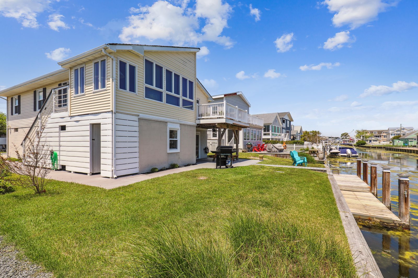 A charming waterfront property situated on a quiet canal, offering a private dock, spacious lawn, and BBQ area perfect for relaxing evenings outdoors.
