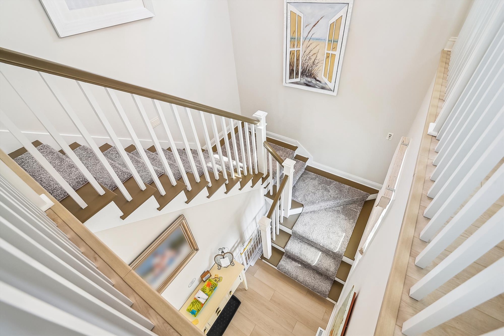 Ascend these elegant carpeted stairs to your private retreat, where thoughtful touches and coastal artwork create a welcoming atmosphere.