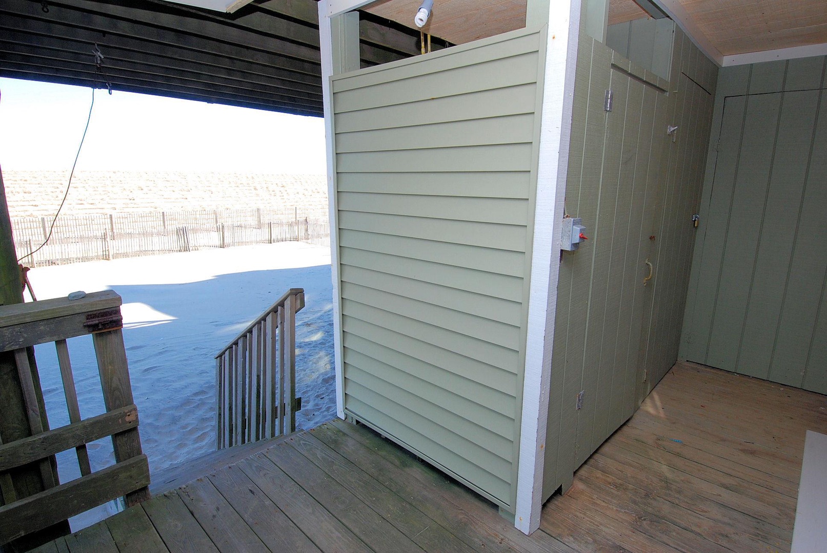 Outdoor shower with beach access awaits just steps from the sand—rinse off salt and sun before heading inside for a cozy evening.