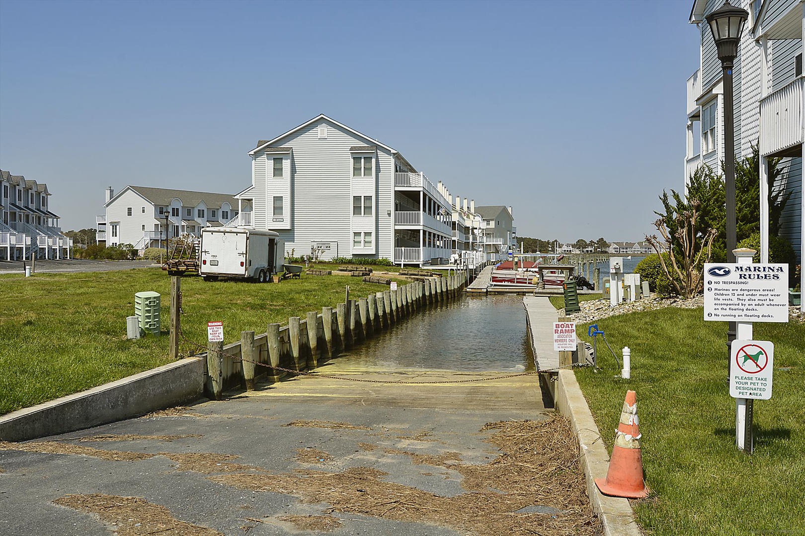 Waterfront community featuring white coastal buildings along a boat-accessible canal with marina facilities and nearby docks.