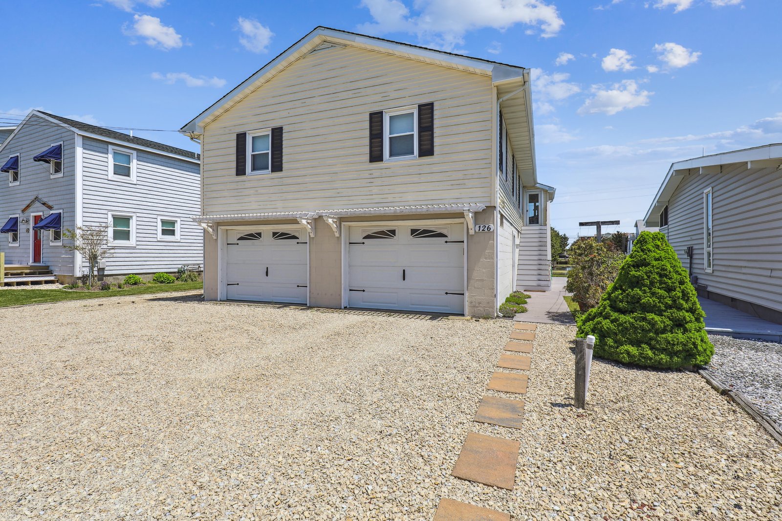 This coastal-style property features a two-car garage and private parking area, nestled in a quiet neighborhood with easy access to local attractions.