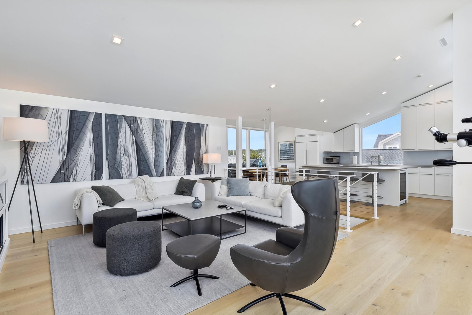 Settle into plush white sofas and modern seating, where clean lines and natural light create a sophisticated atmosphere. Your open-concept living and kitchen space flows seamlessly, ideal for relaxed conversations or entertaining.