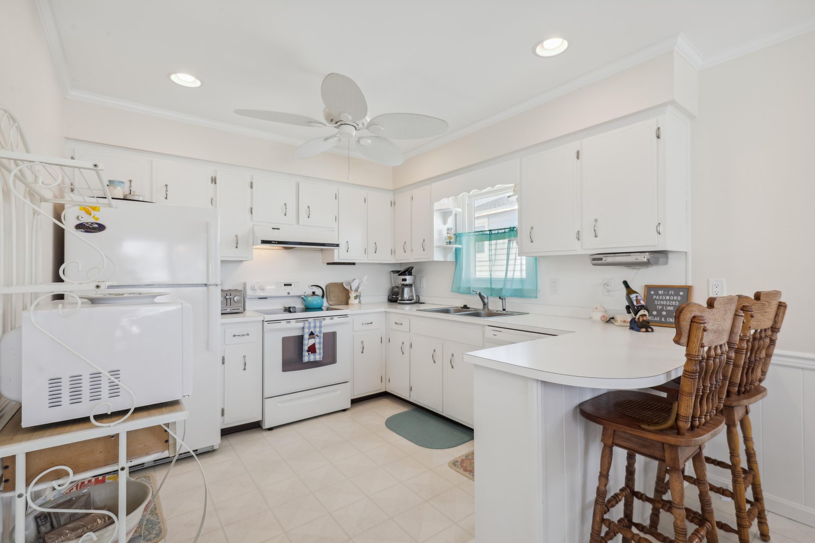 Step into your bright, fully equipped kitchen with classic white cabinetry, modern appliances, and a cozy breakfast bar—perfect for whipping up morning coffee or enjoying a home-cooked meal during your getaway.
