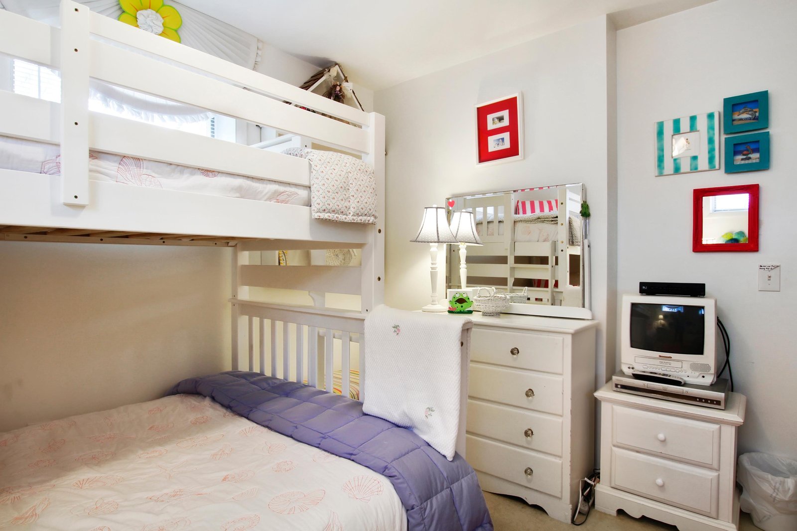 This cheerful bedroom features both a full bed and a cozy bunk above, all bathed in natural light—perfect for the whole family to rest after your beach adventures.