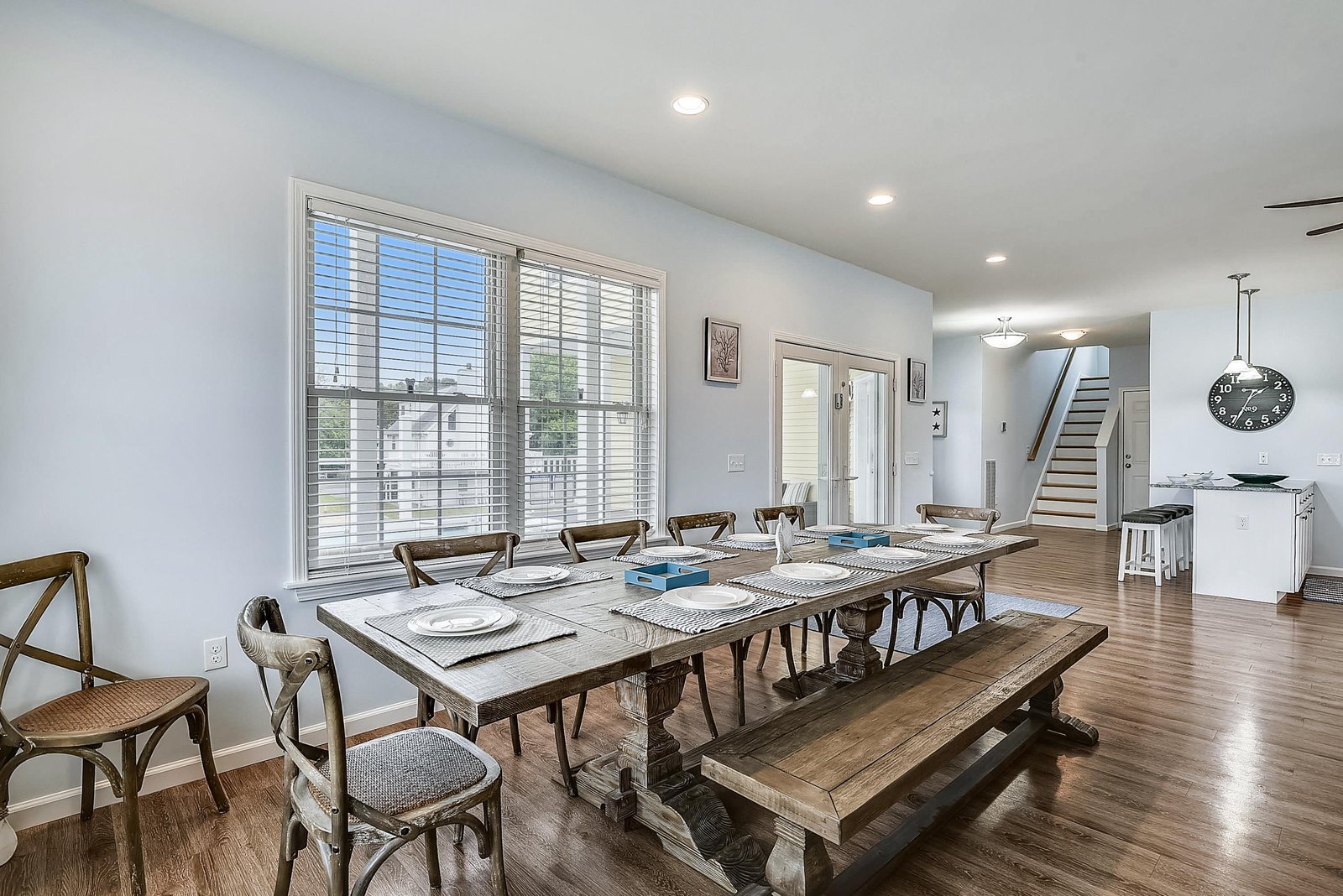 Gather everyone around this spacious farmhouse-style dining table, where hearty meals and easy conversation become your daily ritual in a bright, welcoming space.