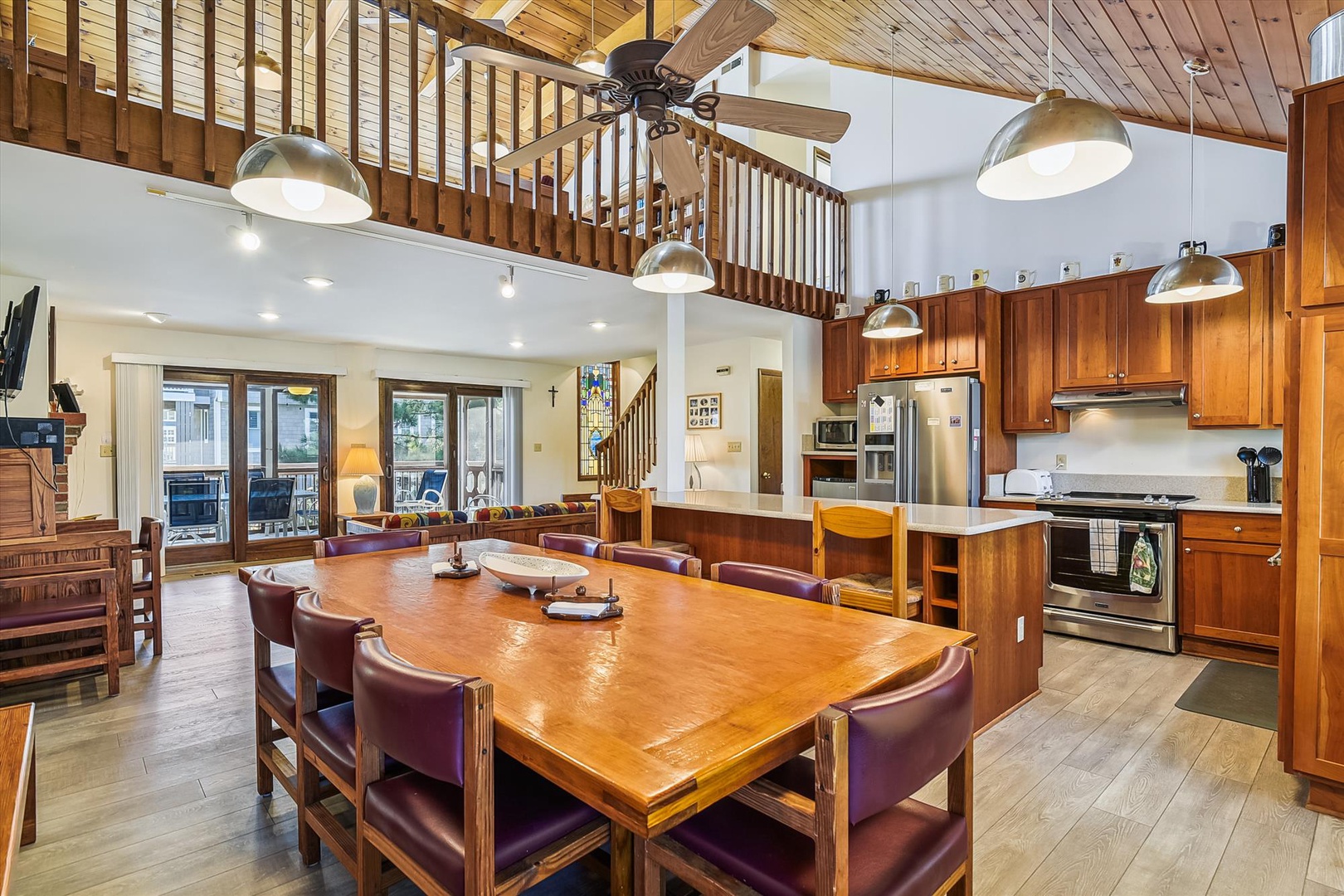 Gather around the spacious dining table under soaring vaulted ceilings with warm wood accents. The open layout connects you to the full kitchen and cozy living spaces, perfect for making memories together.