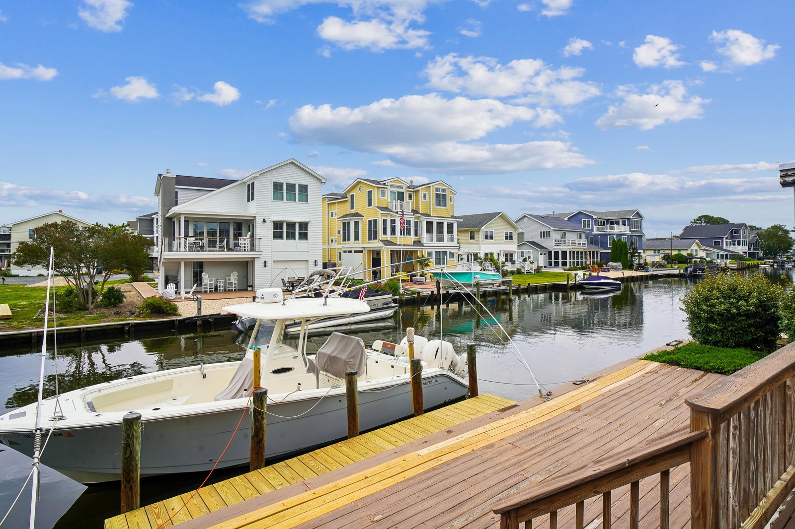 The property is situated in a picturesque waterfront community with private boat docks along a tranquil canal, surrounded by charming coastal homes and scenic water views.