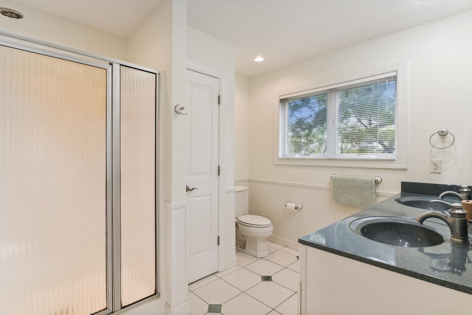 Step into your bright, spotless bathroom with sleek counters, a walk-in shower, and a sunny window—your private space to refresh and unwind.