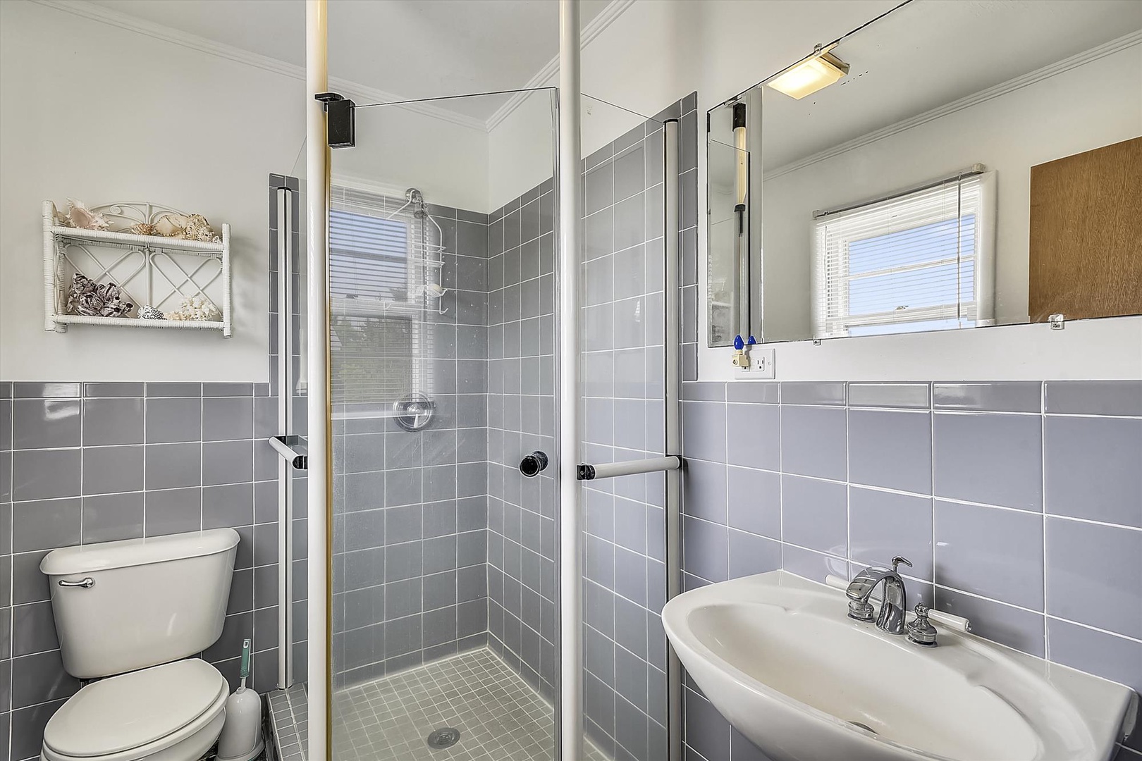 Refresh in this thoughtfully updated bathroom featuring sleek gray tile, a spacious walk-in shower, and bright natural light to start your day.