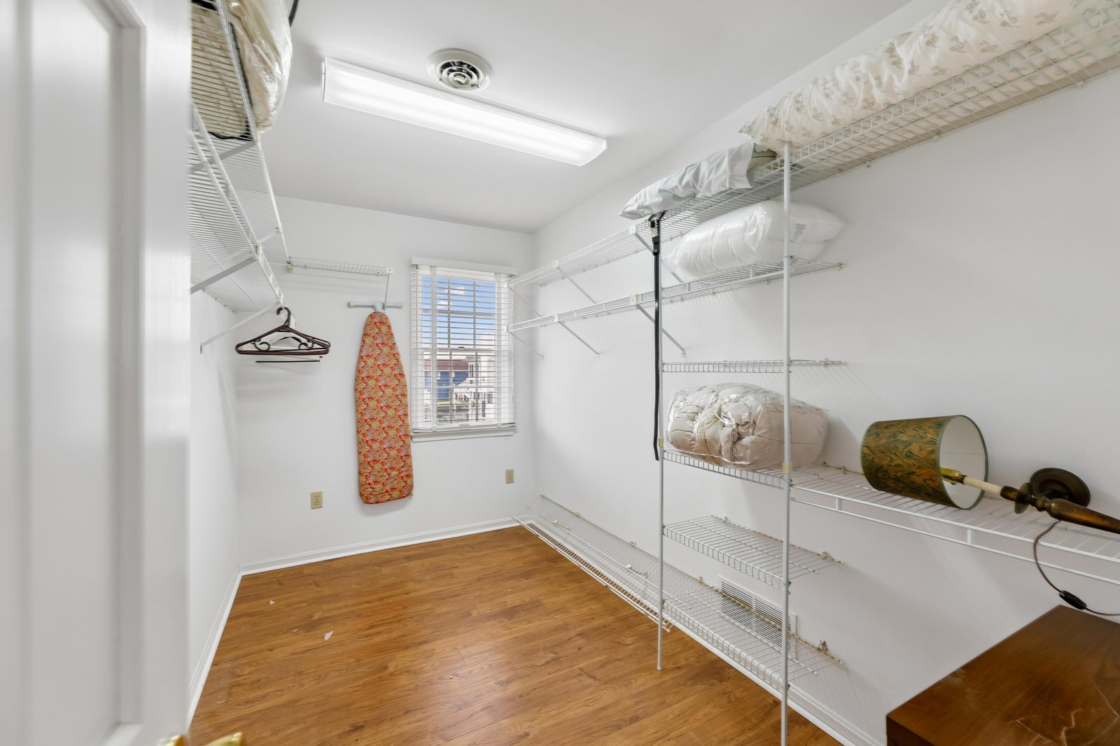 Keep everything tidy in your spacious walk-in closet, complete with built-in shelving and a convenient ironing board for easy unpacking and settling in.