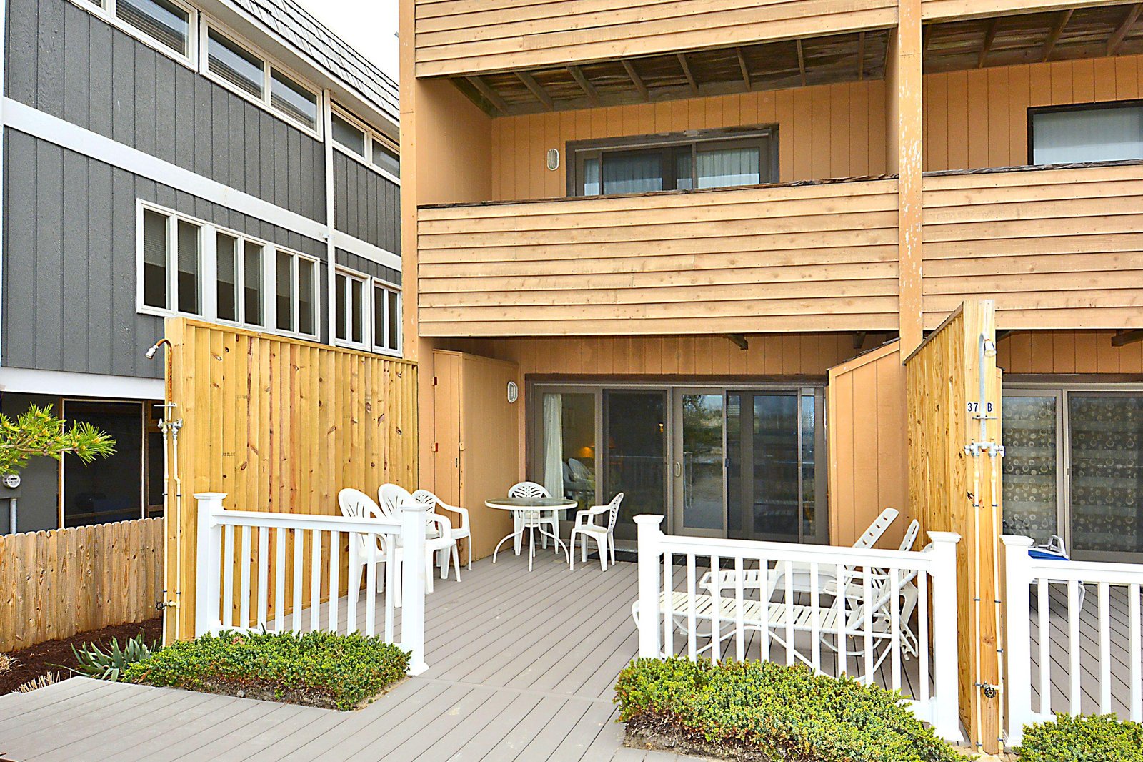 Your private terrace offers a welcoming space to unwind with morning coffee or evening conversation, framed by natural wood and greenery for a peaceful outdoor retreat.