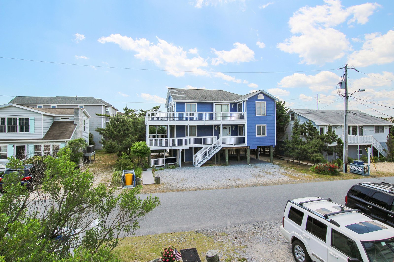 This coastal property features a distinctive blue exterior and elevated design typical of beach communities, offering convenient access to nearby shores.
