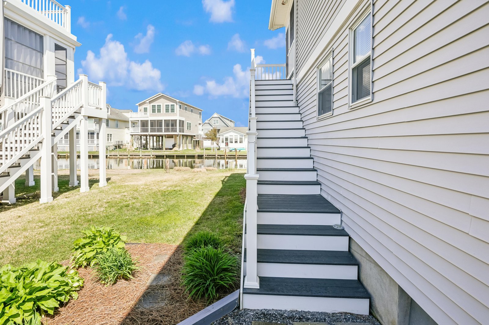 Coastal neighborhood with elevated beach homes and shared green spaces, offering easy access to nearby waterfront amenities.