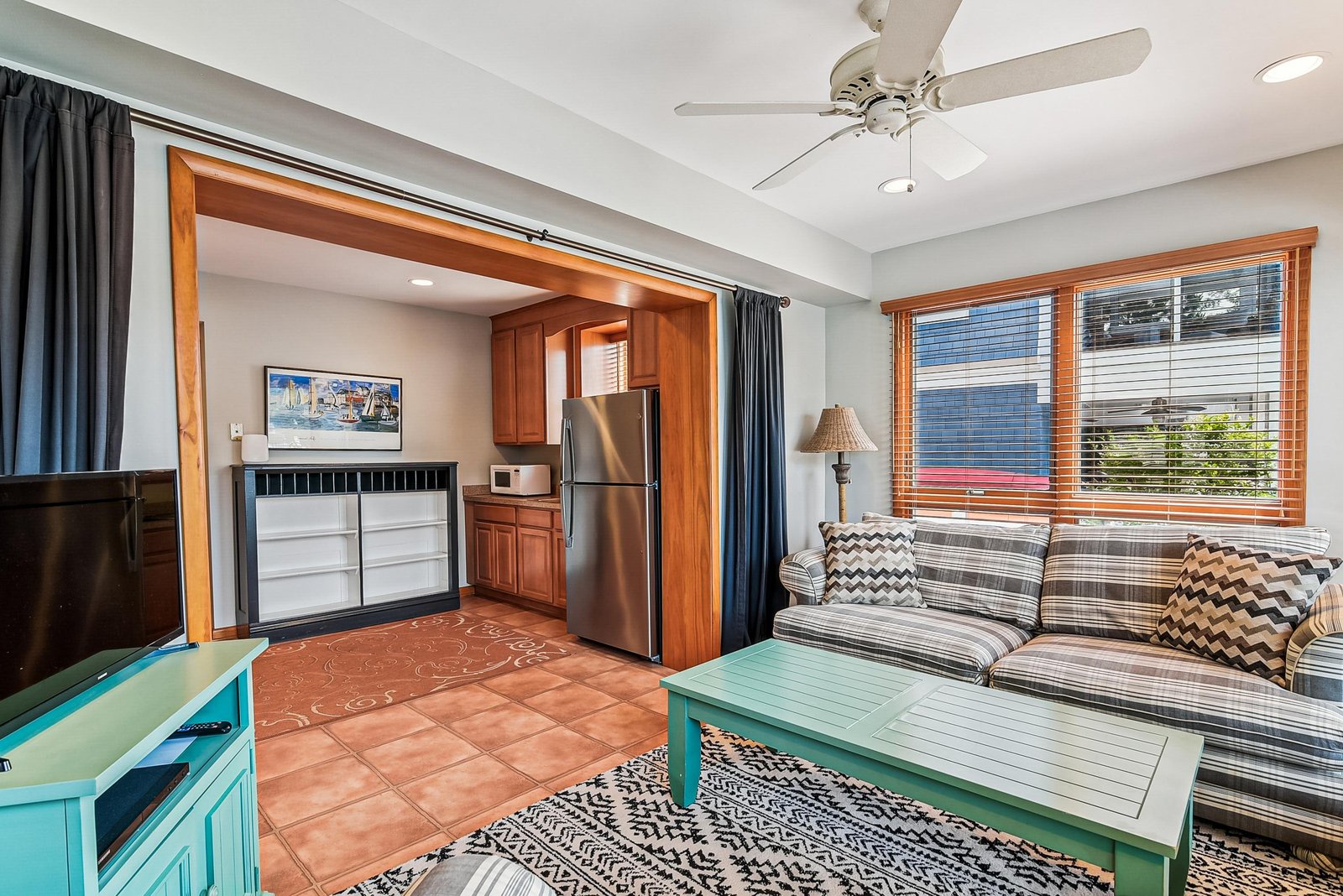 Settle in and enjoy the breeze from the ceiling fan as you relax on the cozy sofa. Your fully equipped kitchenette is just steps away.