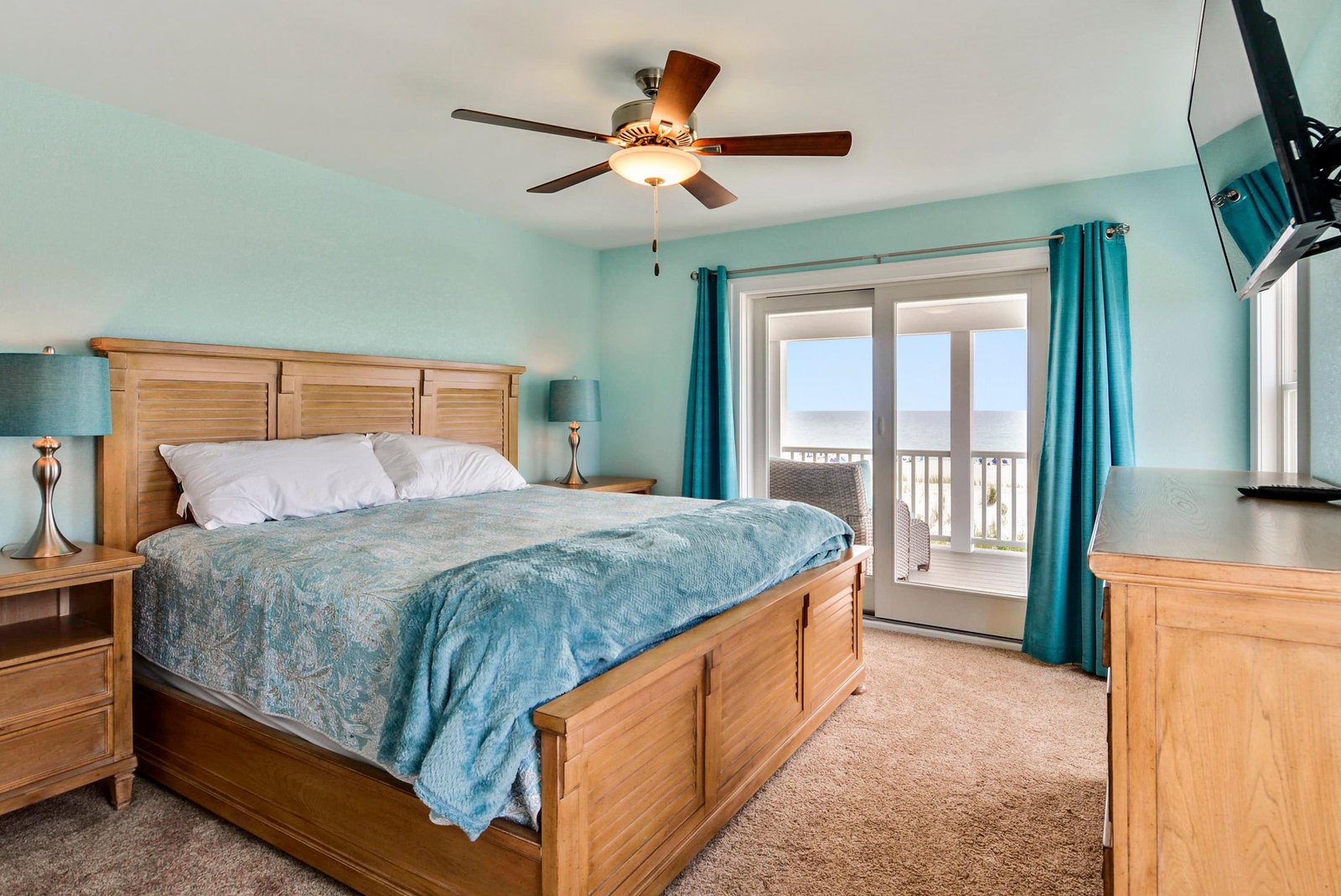 Step into your tranquil coastal bedroom, where soft turquoise walls and warm wood tones create a soothing escape. Wake up to ocean breezes and step onto your private balcony to greet the sea.