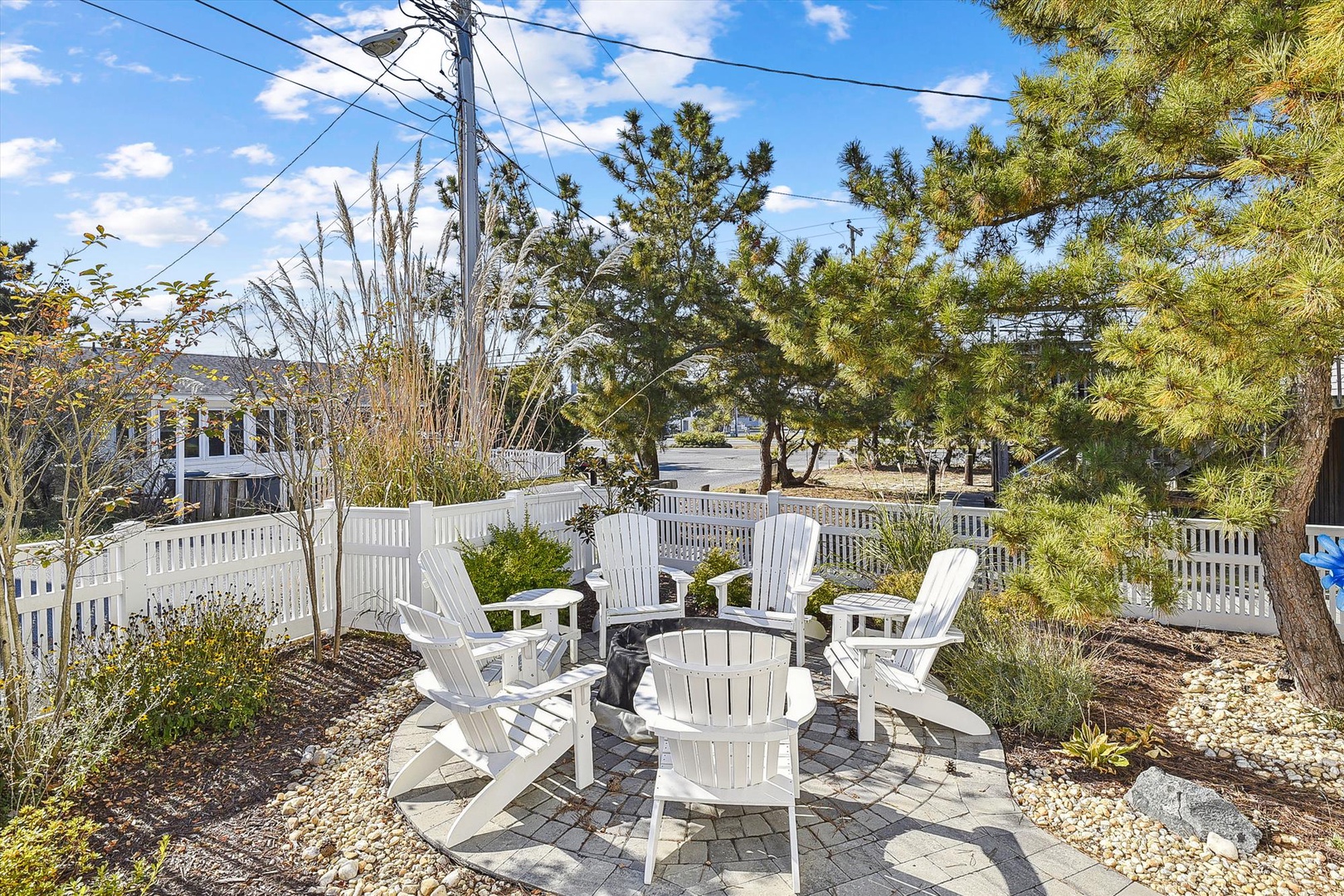 Charming outdoor seating area surrounded by coastal greenery—perfect for morning coffee or evening gatherings under the open sky in a peaceful neighborhood setting.