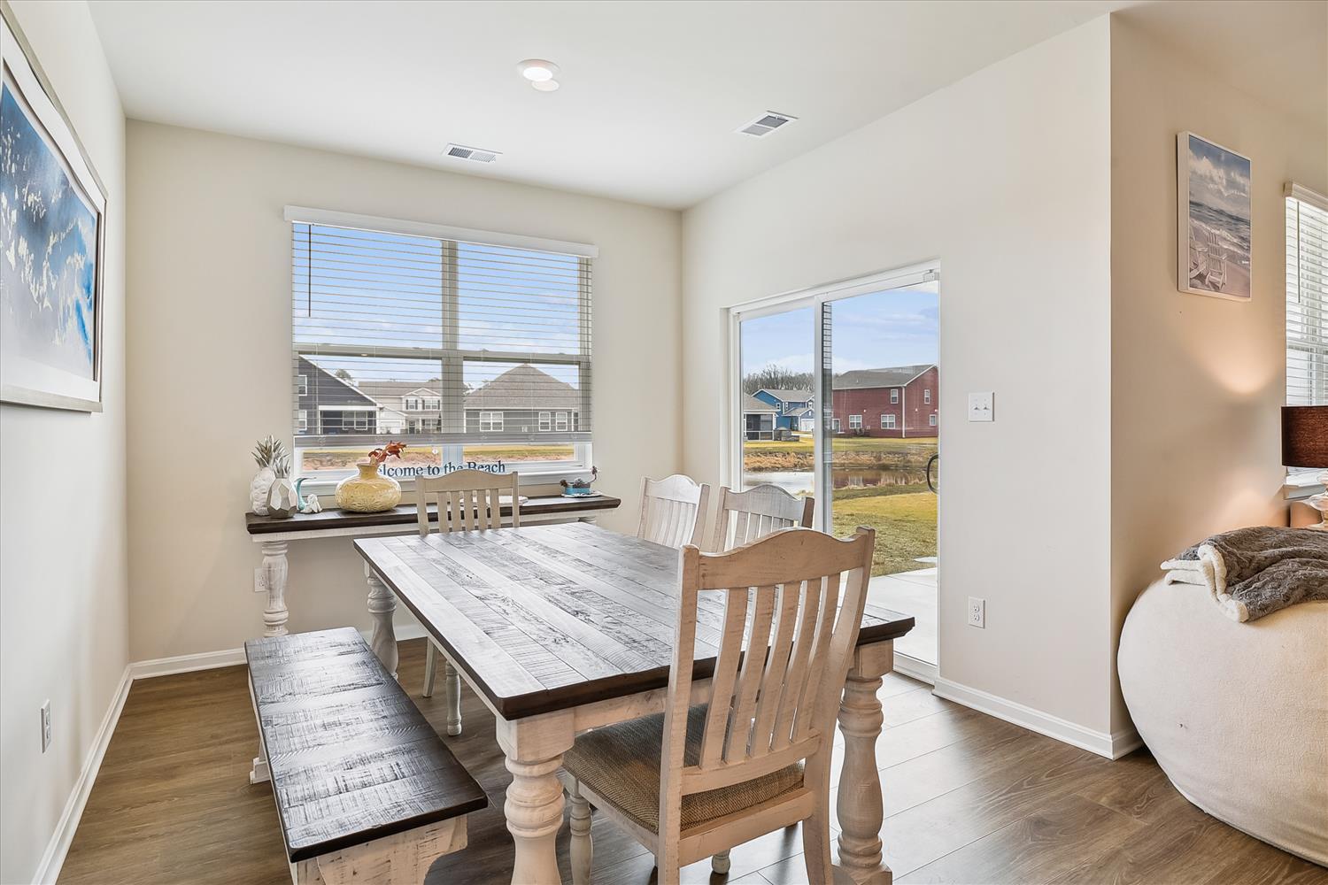 Gather around this rustic farmhouse dining table, where coastal charm meets comfort. Sunlight streams through large windows while you enjoy meals with loved ones in this inviting space.