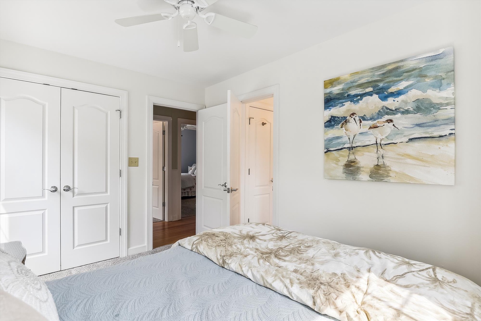 Drift off in your peaceful bedroom with coastal artwork and a ceiling fan keeping you comfortable. The soft bedding and bright, airy space create a soothing retreat after a day of exploring.