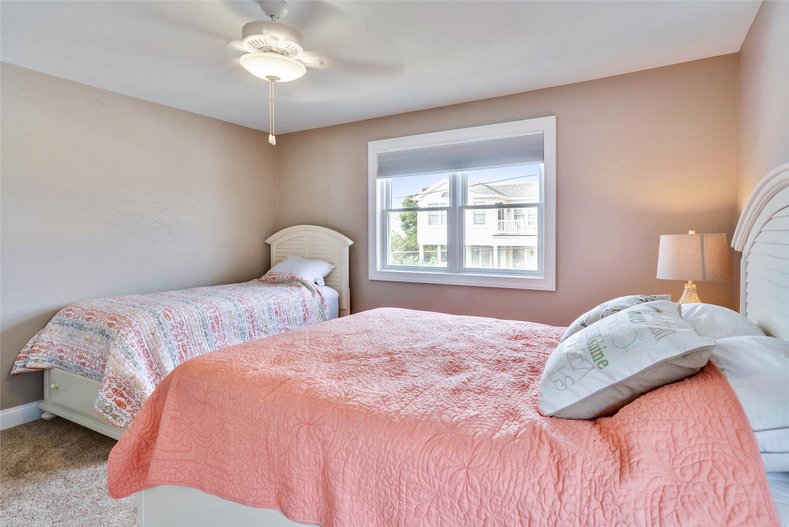 Drift off in this serene bedroom with two cozy beds dressed in soft quilts. The ceiling fan keeps you comfortable, while natural light streams through the window, creating a peaceful retreat after a day of adventure.