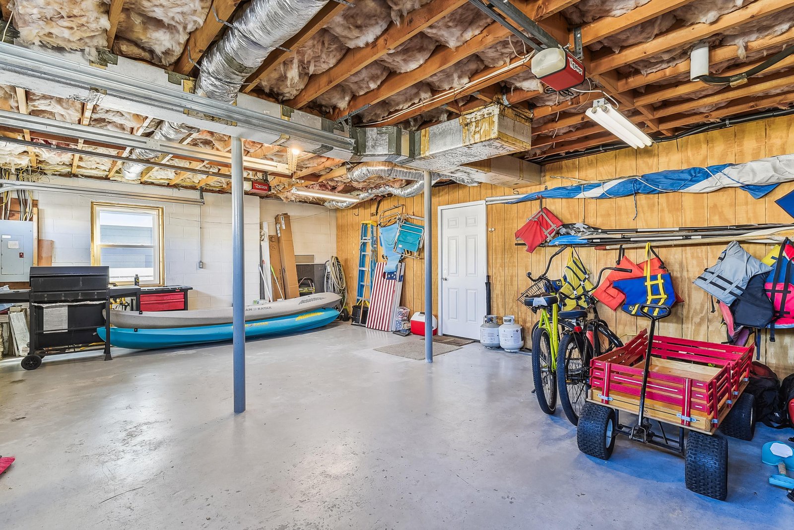Spacious storage area stocked with bikes, kayaks, life jackets, and beach gear—everything you need for your next adventure is already here.
