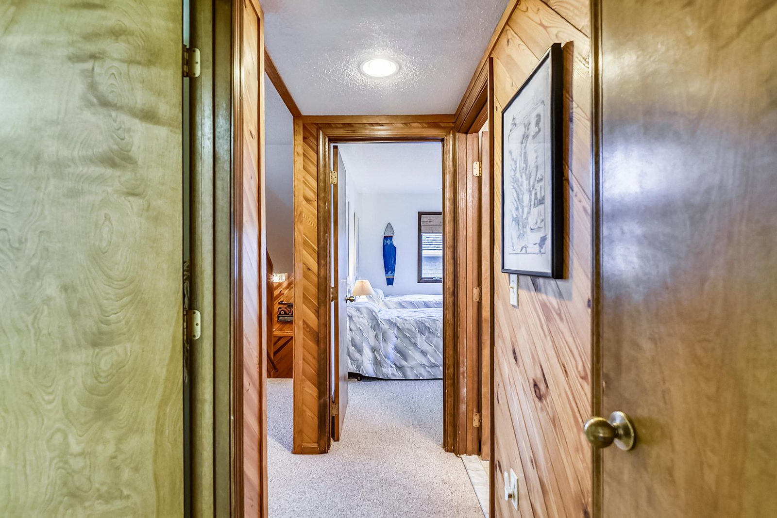A warm hallway connects your private spaces, with natural wood tones and soft lighting creating a cozy, cabin-like atmosphere throughout.