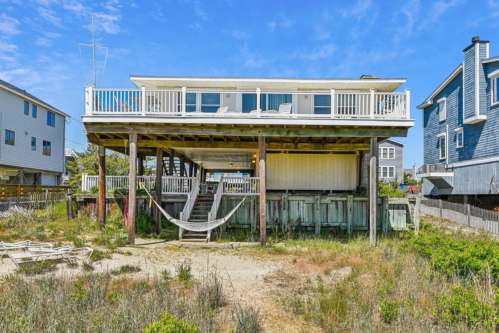 A beachside property set on elevated stilts with a spacious upper deck and hammock area, offering a relaxed coastal retreat with direct beach access.