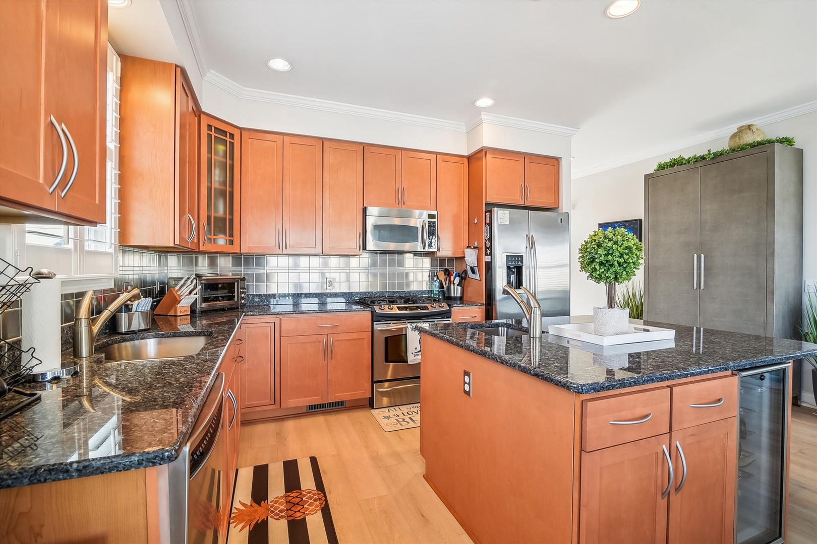 You'll love preparing meals in this spacious kitchen, featuring sleek granite countertops, stainless-steel appliances, and abundant cabinetry for all your culinary needs.