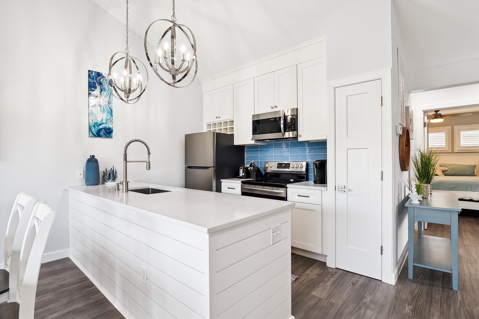 A bright, welcoming kitchen awaits you with modern appliances, a spacious island, and elegant chandeliers overhead. Cook your favorite meals in this inviting space with plenty of counter room and storage.