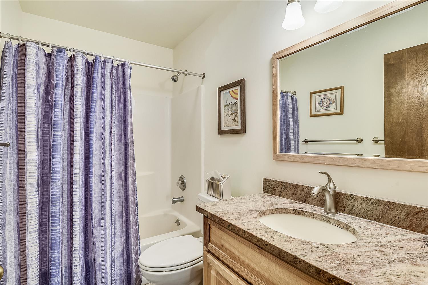 Step into your private bathroom with a soothing color palette and granite countertops, where fresh linens and thoughtful details await your arrival.