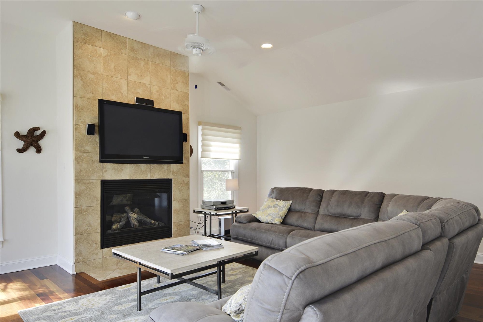 Sink into the plush sectional and unwind by your private fireplace, where vaulted ceilings and coastal charm create your perfect retreat.