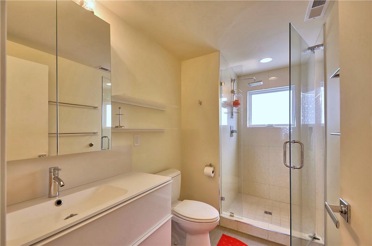Freshen up in your sleek modern bathroom with a spacious walk-in shower and plenty of storage.