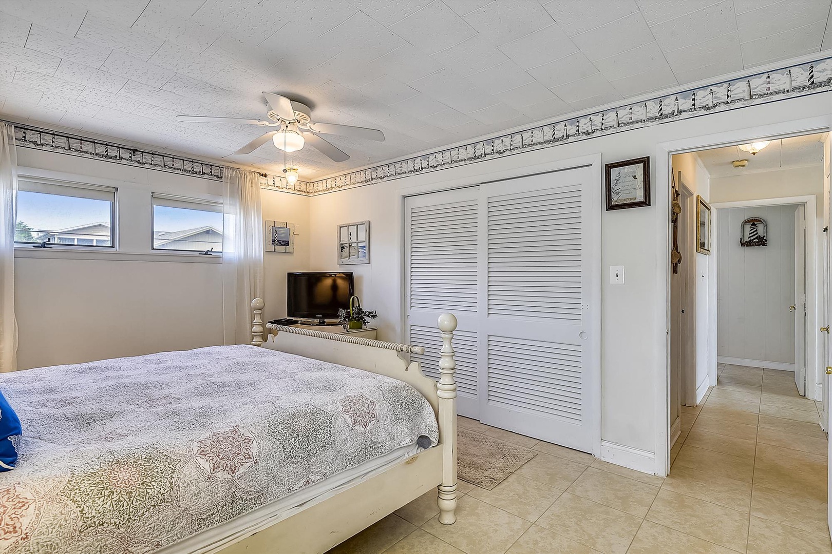 Your bright coastal bedroom features a plush bed, ceiling fan for gentle breezes, flat-screen TV, and ample closet space—a serene retreat after beach days.