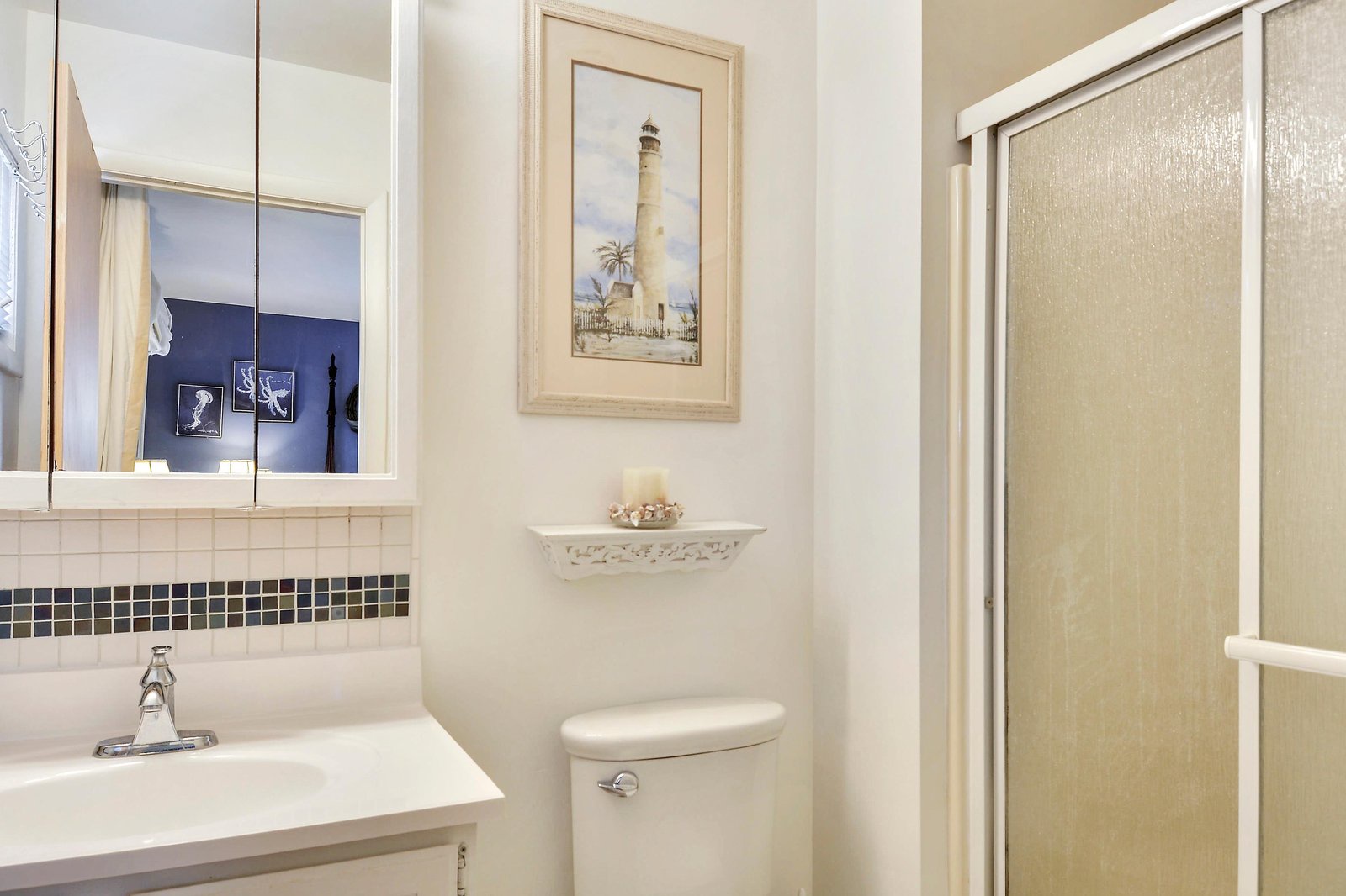Freshen up in your private bathroom with clean tile work, coastal touches, and a spacious shower that invites a moment of calm after your day's adventures.