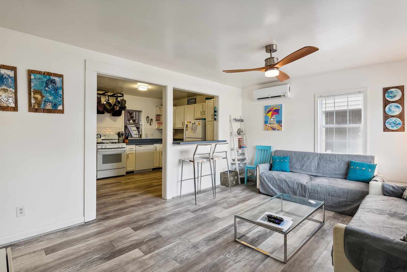 Settle into your bright, open living space where a plush sectional invites you to relax after a beach day. The kitchen is steps away, and coastal artwork adds charm throughout.