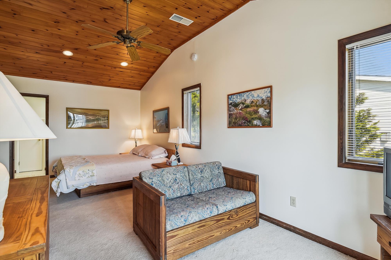 Your cozy retreat features vaulted wood ceilings, a plush bed, and a loveseat perfect for unwinding after exploring the area's natural beauty.