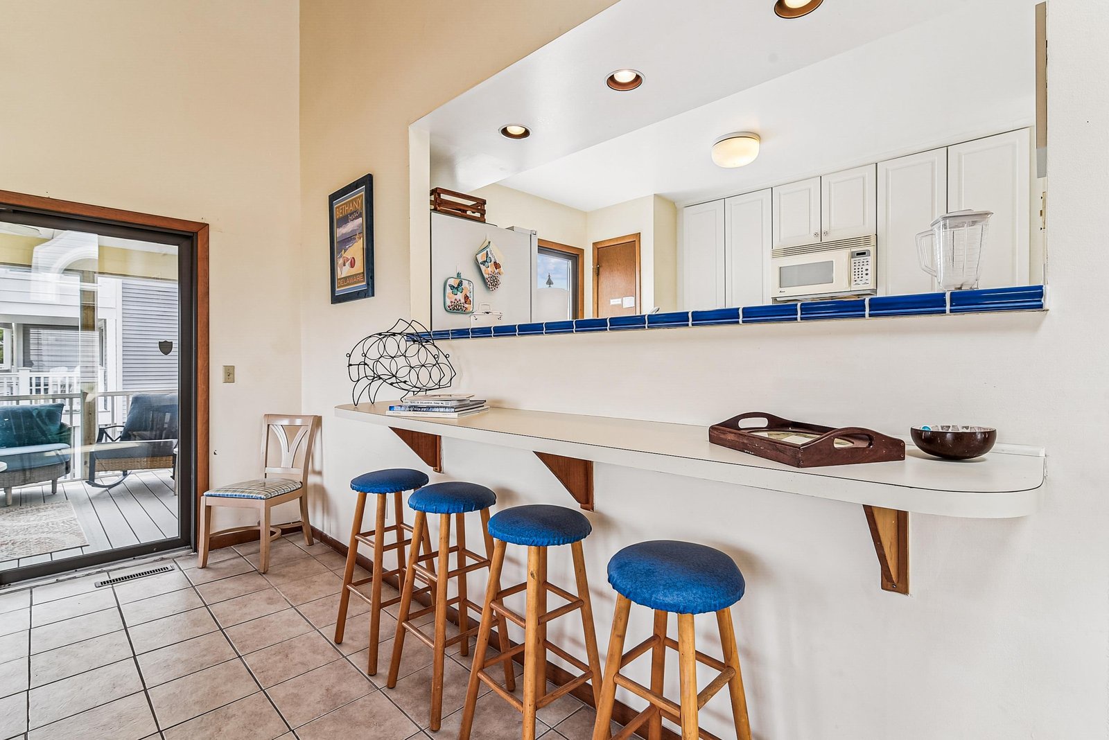 Step into your coastal-inspired kitchen where bright blue accents catch the light. Pull up a stool at the breakfast bar and plan your day over coffee, or gather here for easy meals after your adventures.