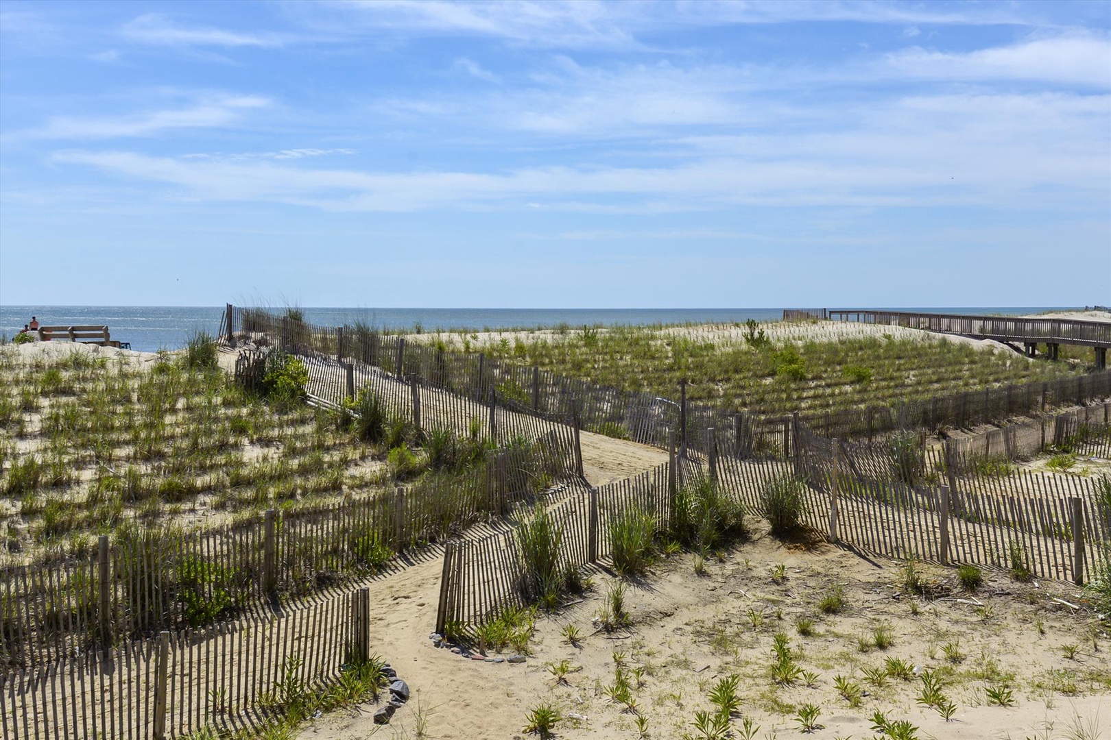 Coastal dunes and beach access boardwalk provide a natural seaside setting near the property.