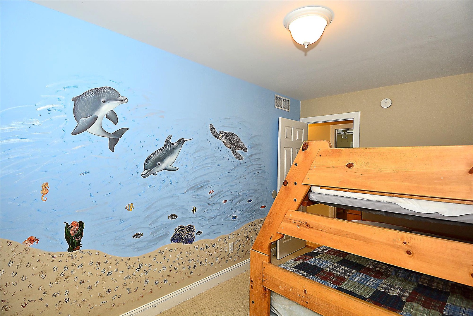Your kids will love drifting off to sleep in this ocean-themed room, complete with playful dolphins, sea turtles, and a cozy bunk bed for shared adventures.