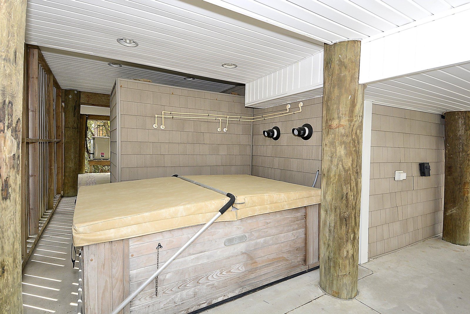 Soak away your cares in your private hot tub, nestled under a covered patio with rustic wood accents and easy outdoor access.